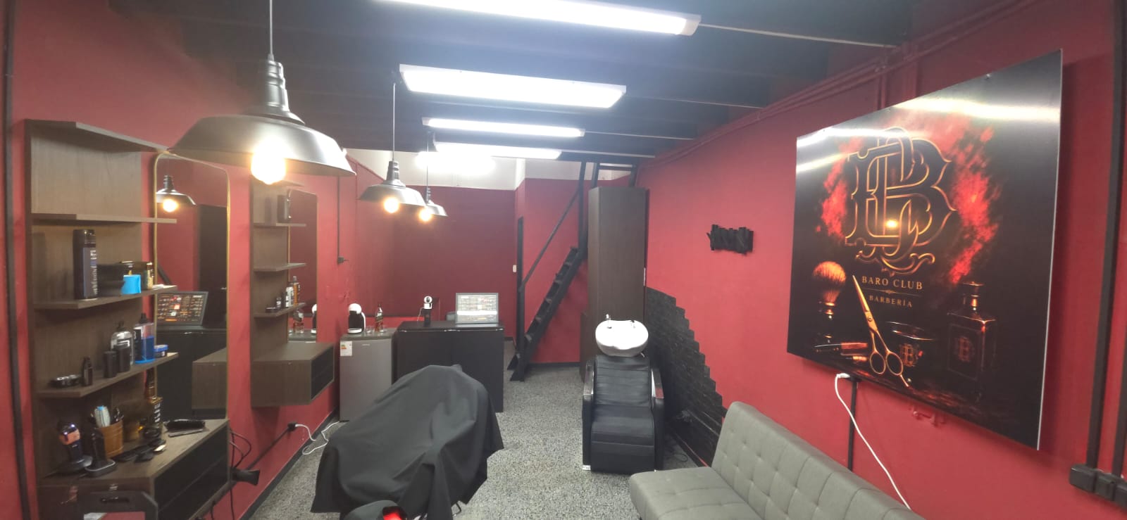 Vista del salón con espejos, estanterías y cuadro del logo